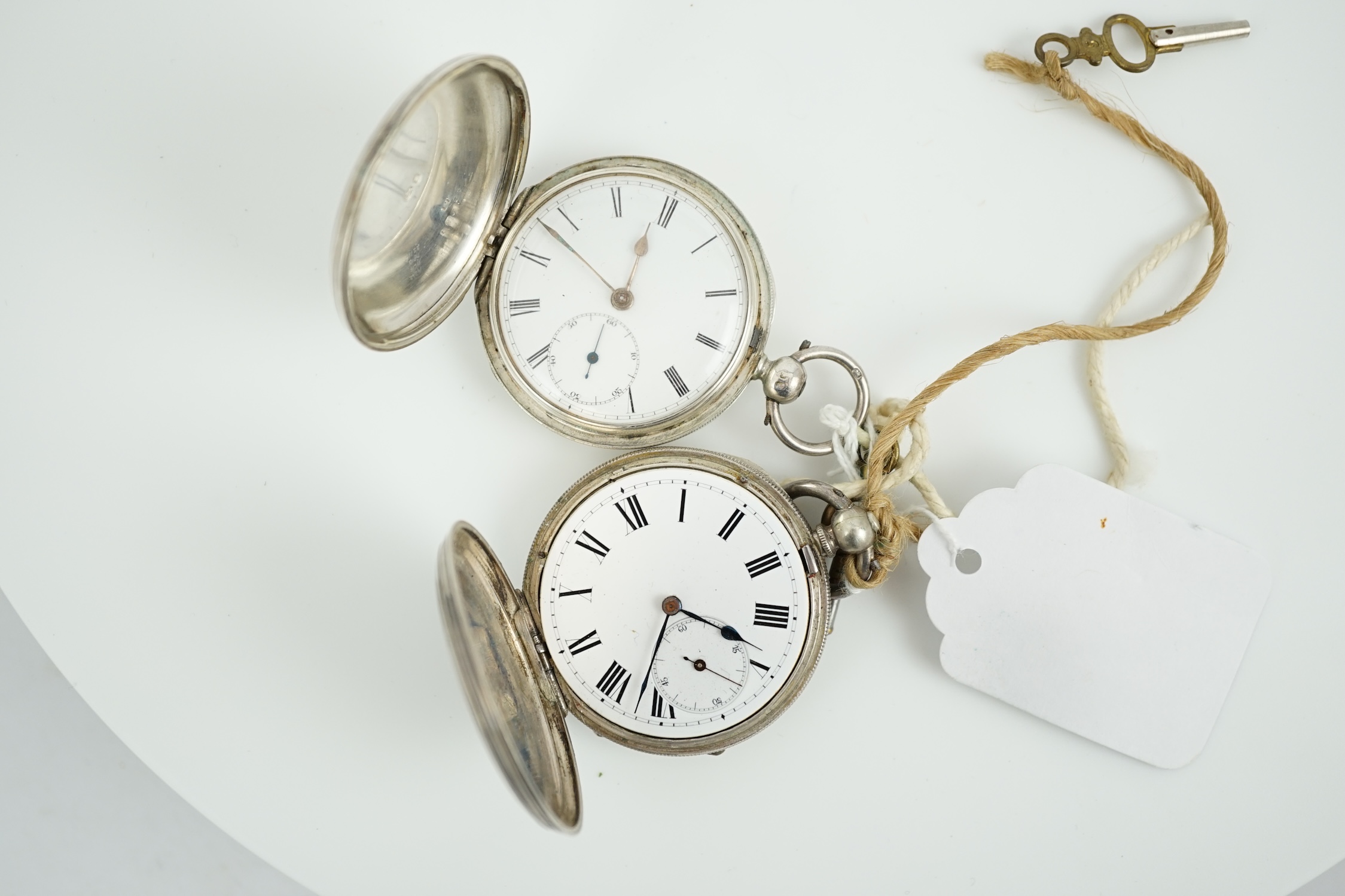 A Victorian silver hunter keywind pocket watch and an engine turned white metal pocket watch.